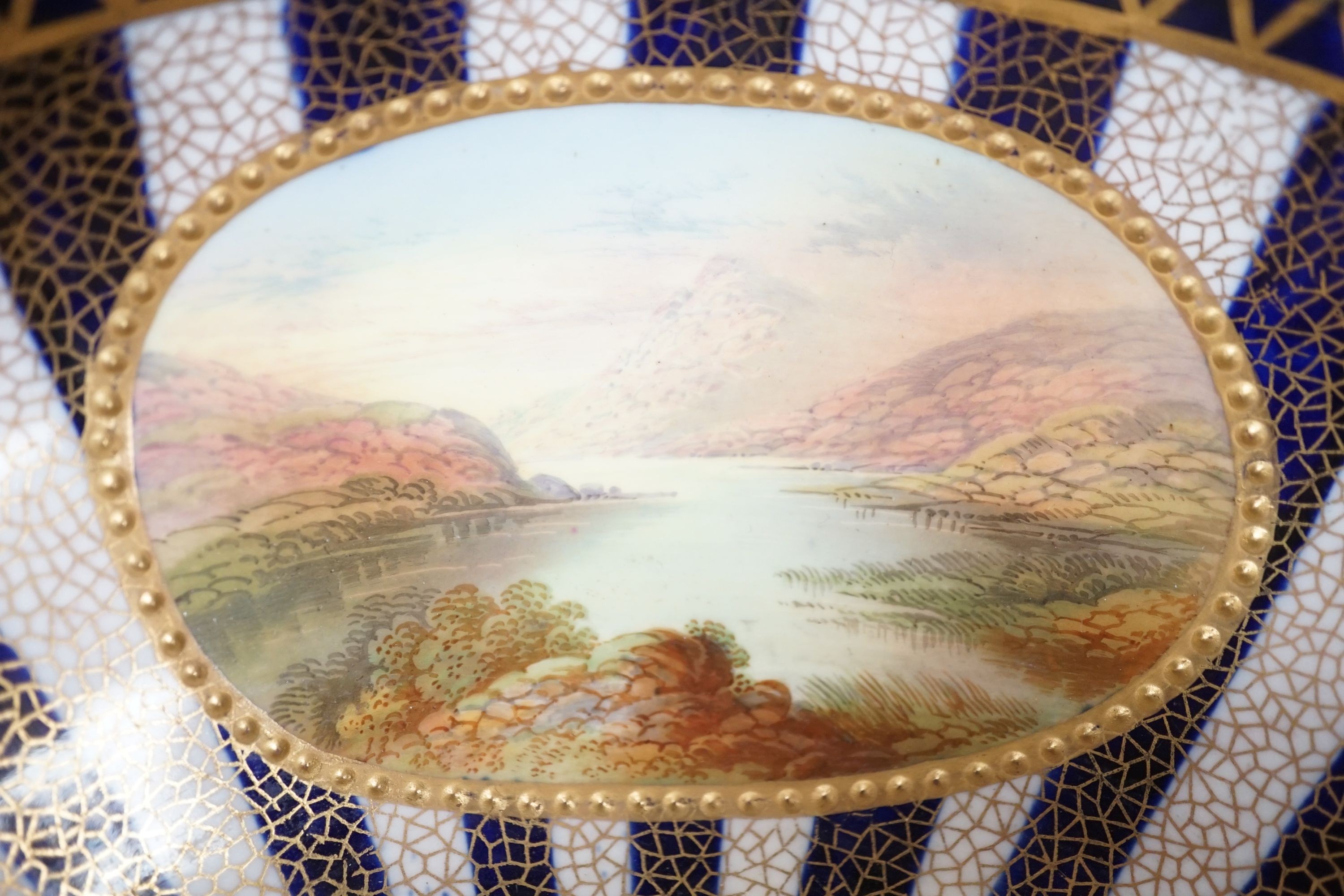 An Aynsley fine bowl with three interior landscape panels and three exterior panels painted with birds between alternating blue and white gilt stripes four panels signed R.J.K. for Richard J. Keeling, c.1910, height 10.5